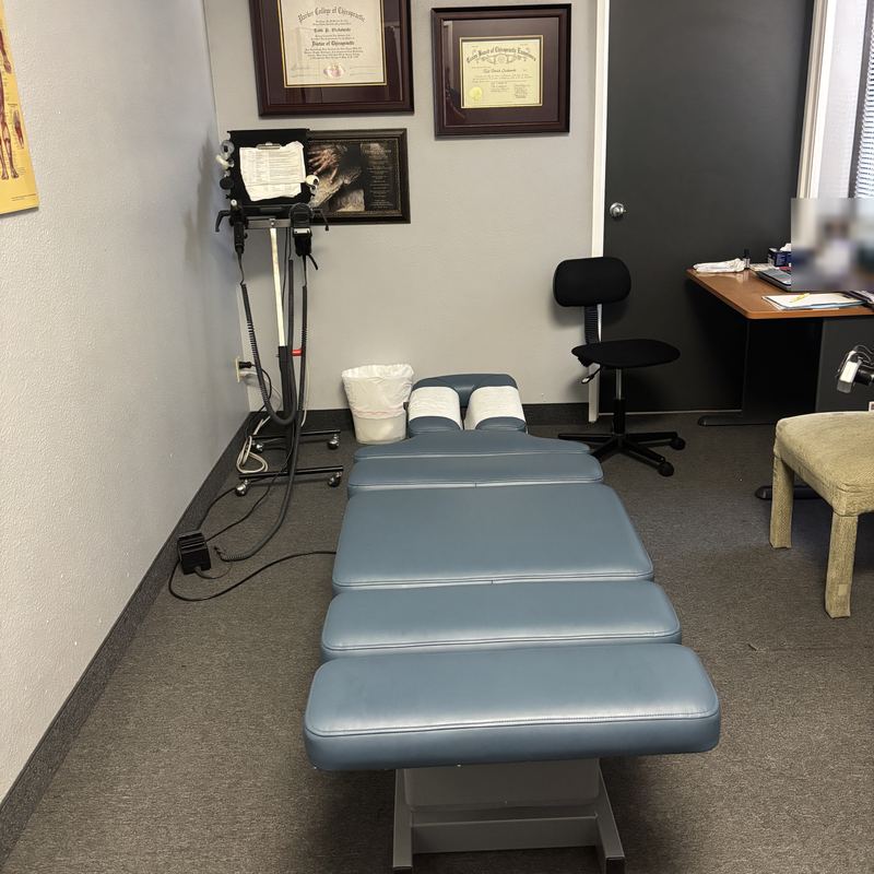 The adjusting room, with Dr. Ozzie's Parker College and Texas Board of Chiropractic Examiners credentials on the wall
