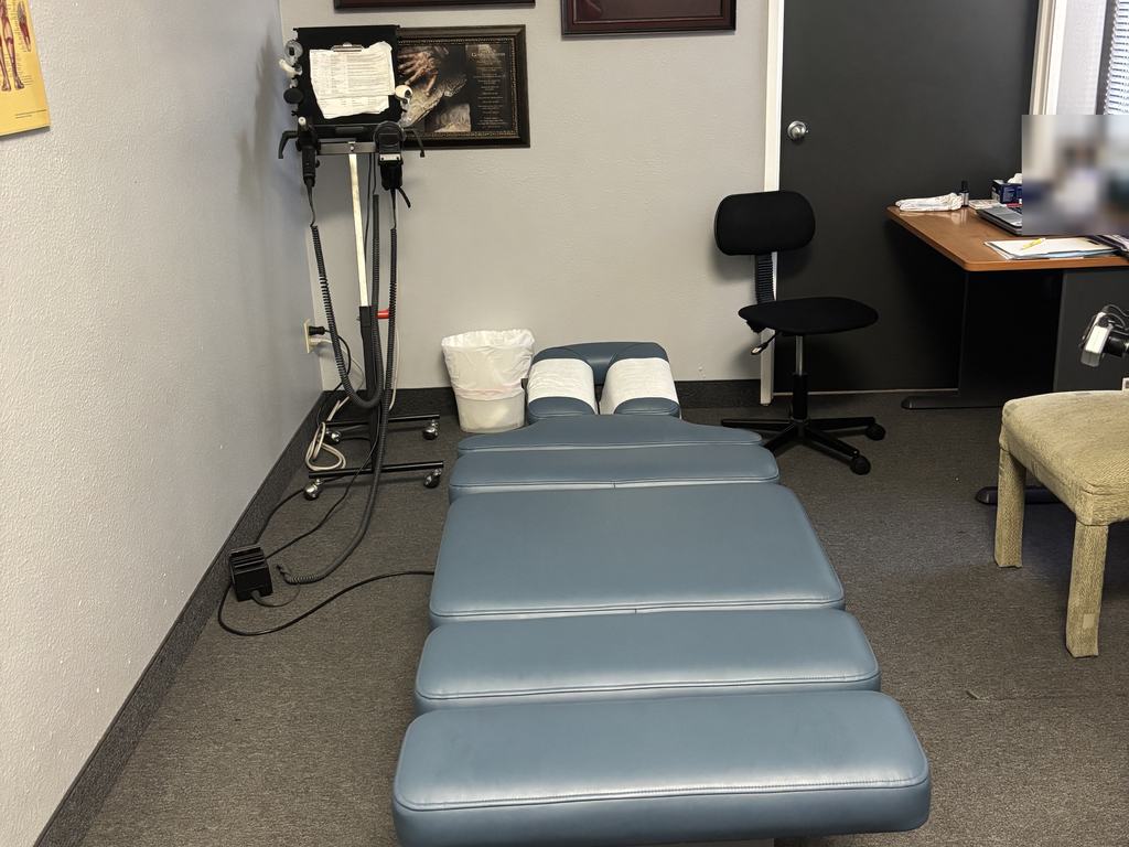 The adjusting room at the Flower Mound office, with the chiropractic table and credentials on the wall